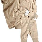Beige baby outfit set with hat, shirt, and pants on a white surface