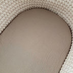 Close-up of a textured beige cushion on a woven beige surface