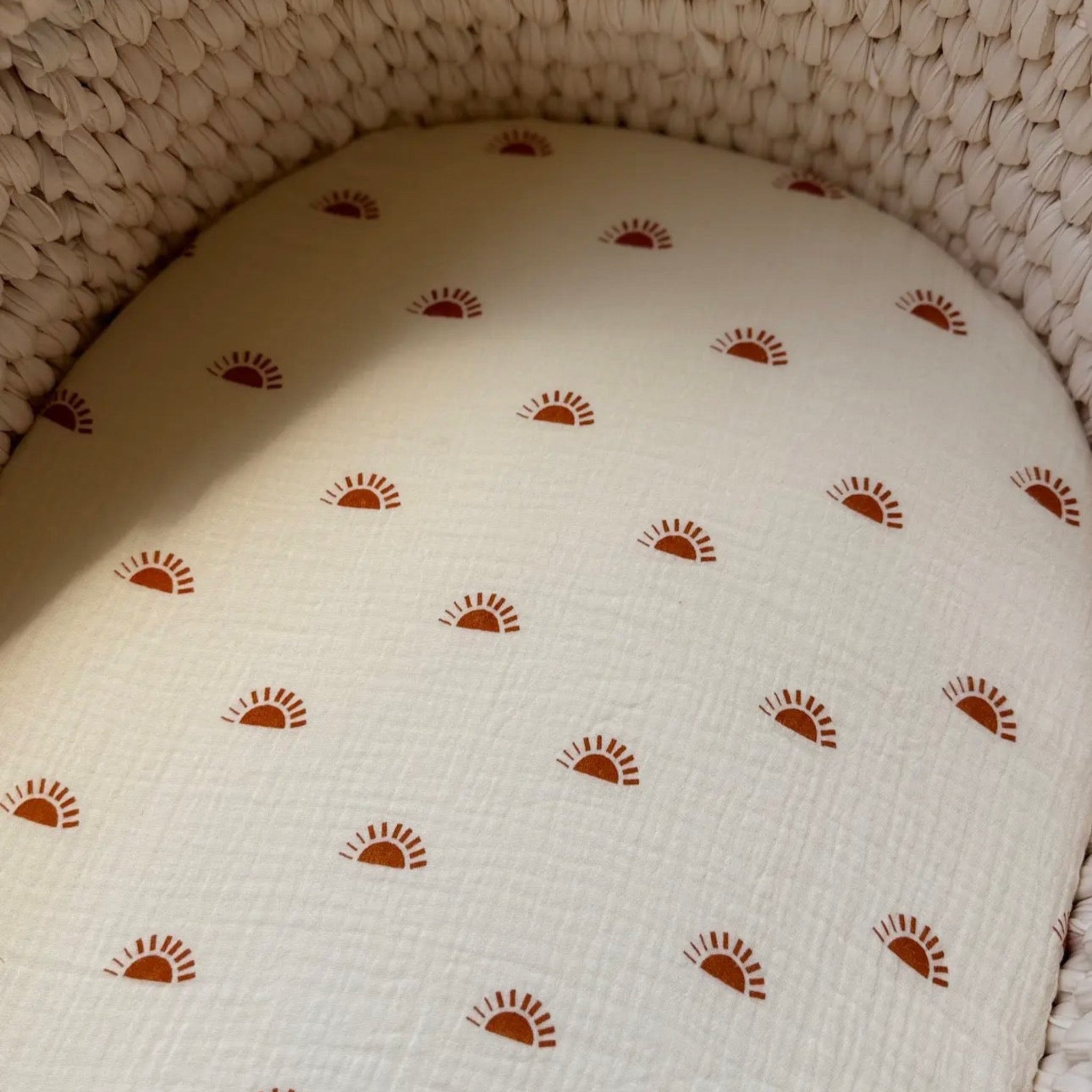 Patterned cushion with sun design on a textured surface