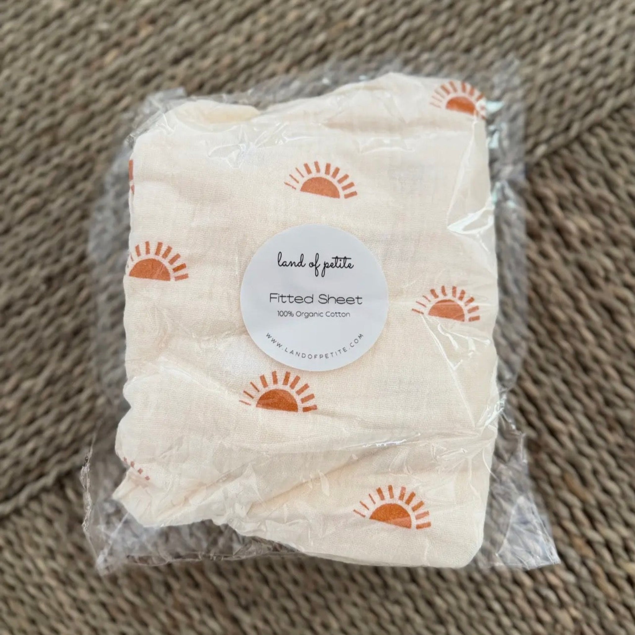 Package of a folded fabric item with a label on a textured brown background