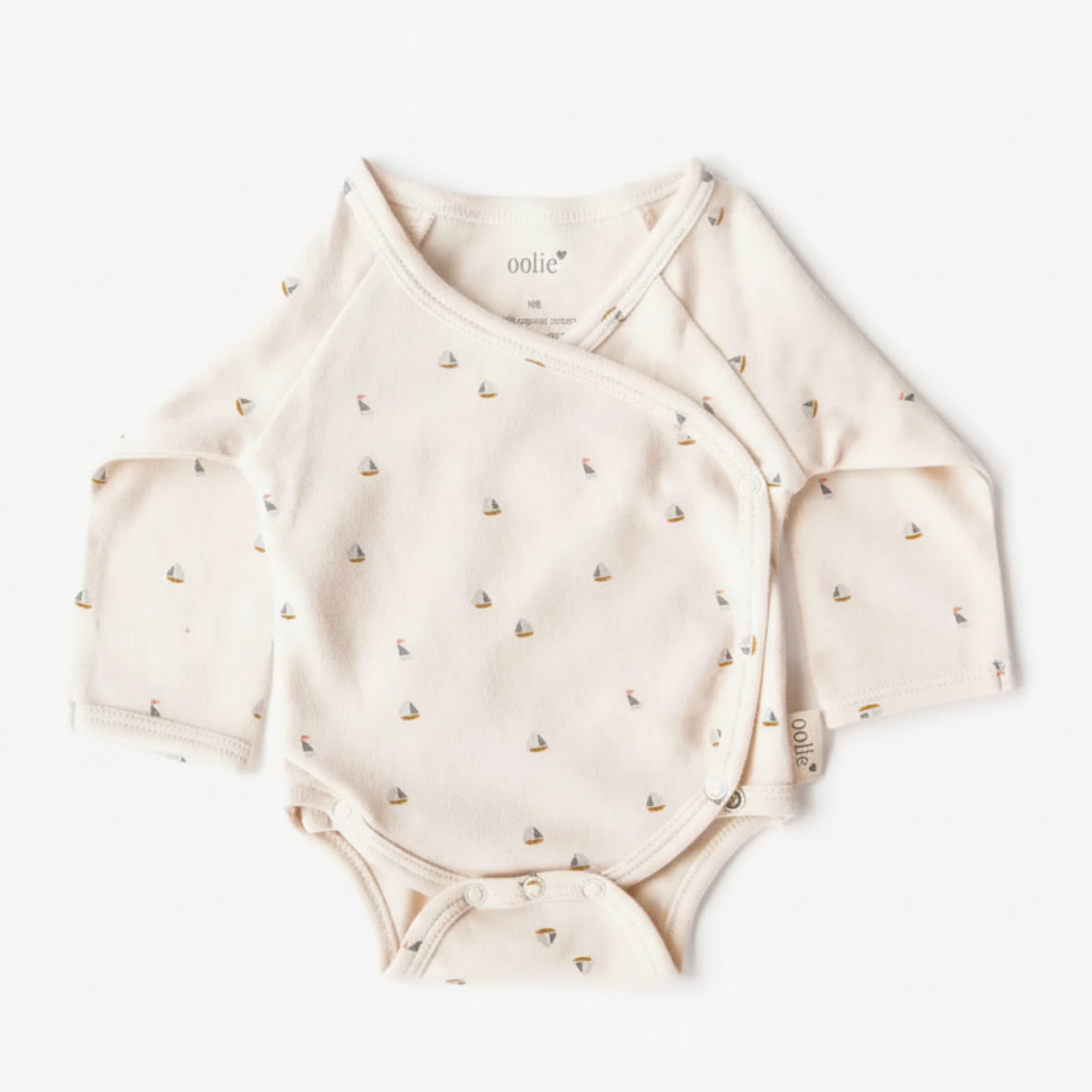 Beige baby onesie with small patterns on a white background