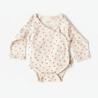 Baby onesie with long sleeves and small patterns on a white background