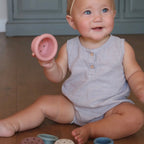 Baby sitting on the floor with colorful play toys