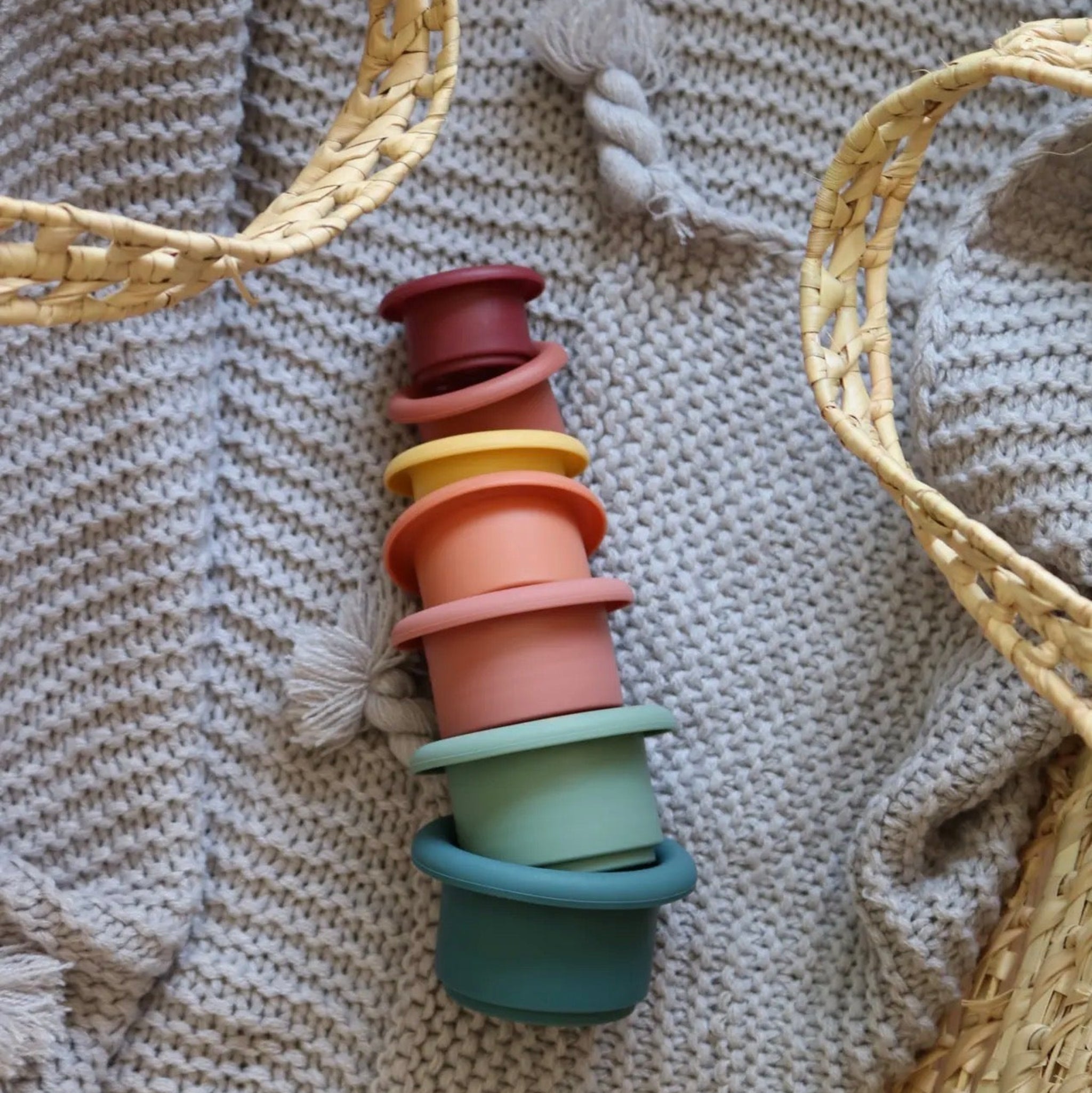 Stack of colorful silicone bottle caps on a textured fabric background