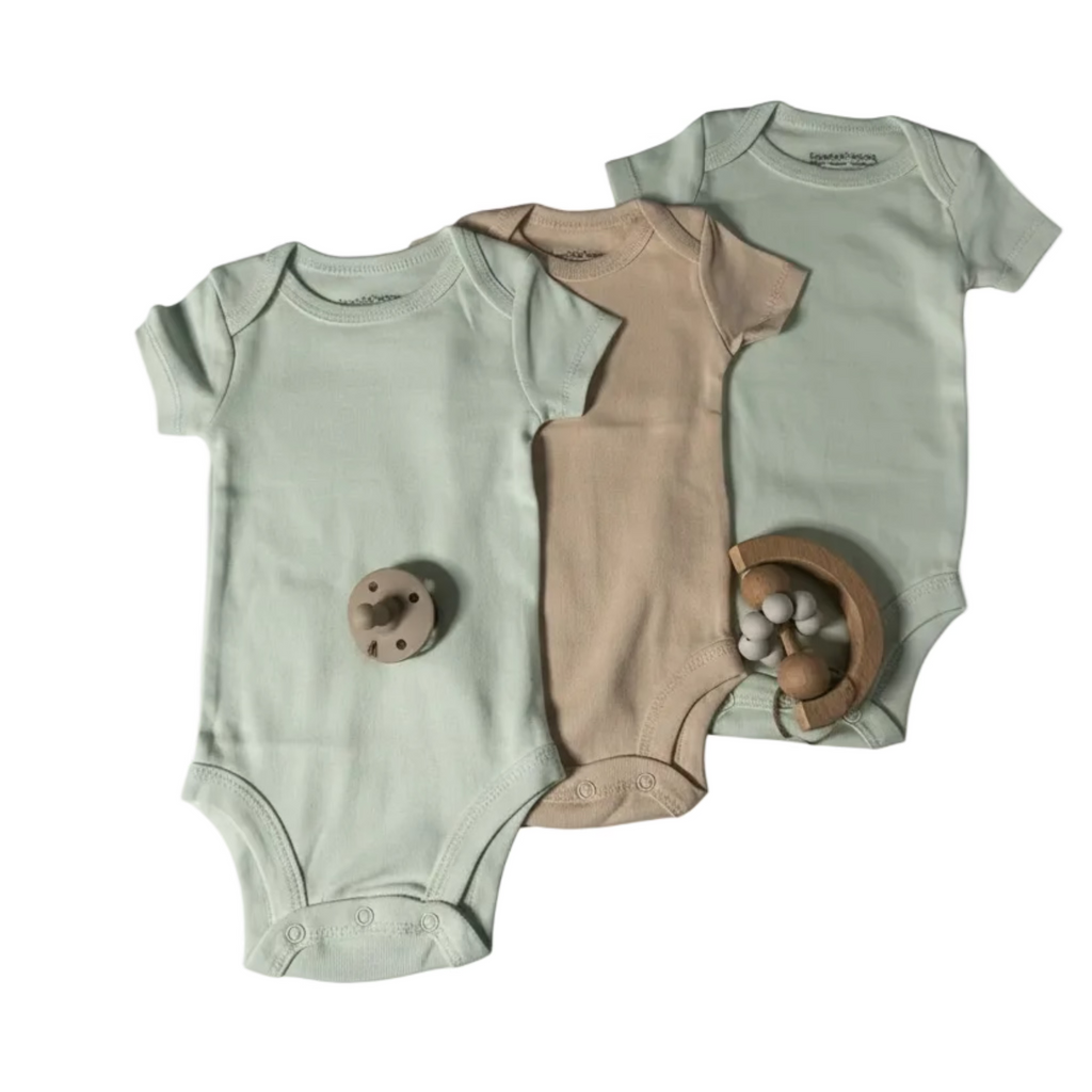 Two baby onesies and a brown romper on a light gray background