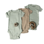 Two baby onesies and a brown romper on a light gray background