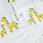 Close-up of white fabric with yellow animal prints, including giraffes and elephants.