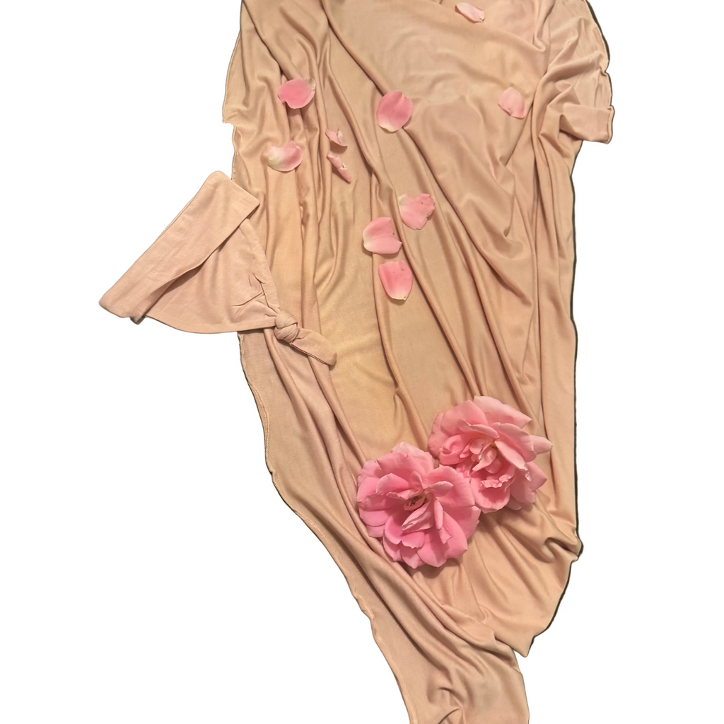Pink bodysuit with floral embellishments on a wooden surface