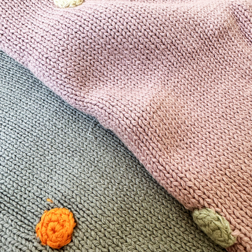 Close-up of textured fabric with colorful buttons on a pink background