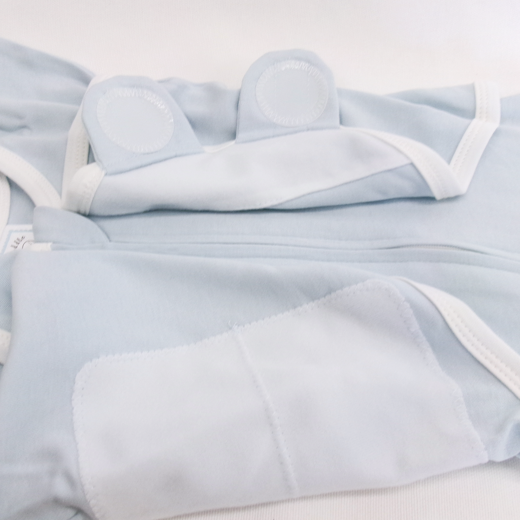 Light blue baby outfit with white trim on a light gray background