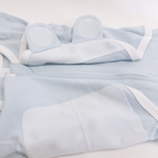 Light blue baby outfit with white trim on a light gray background