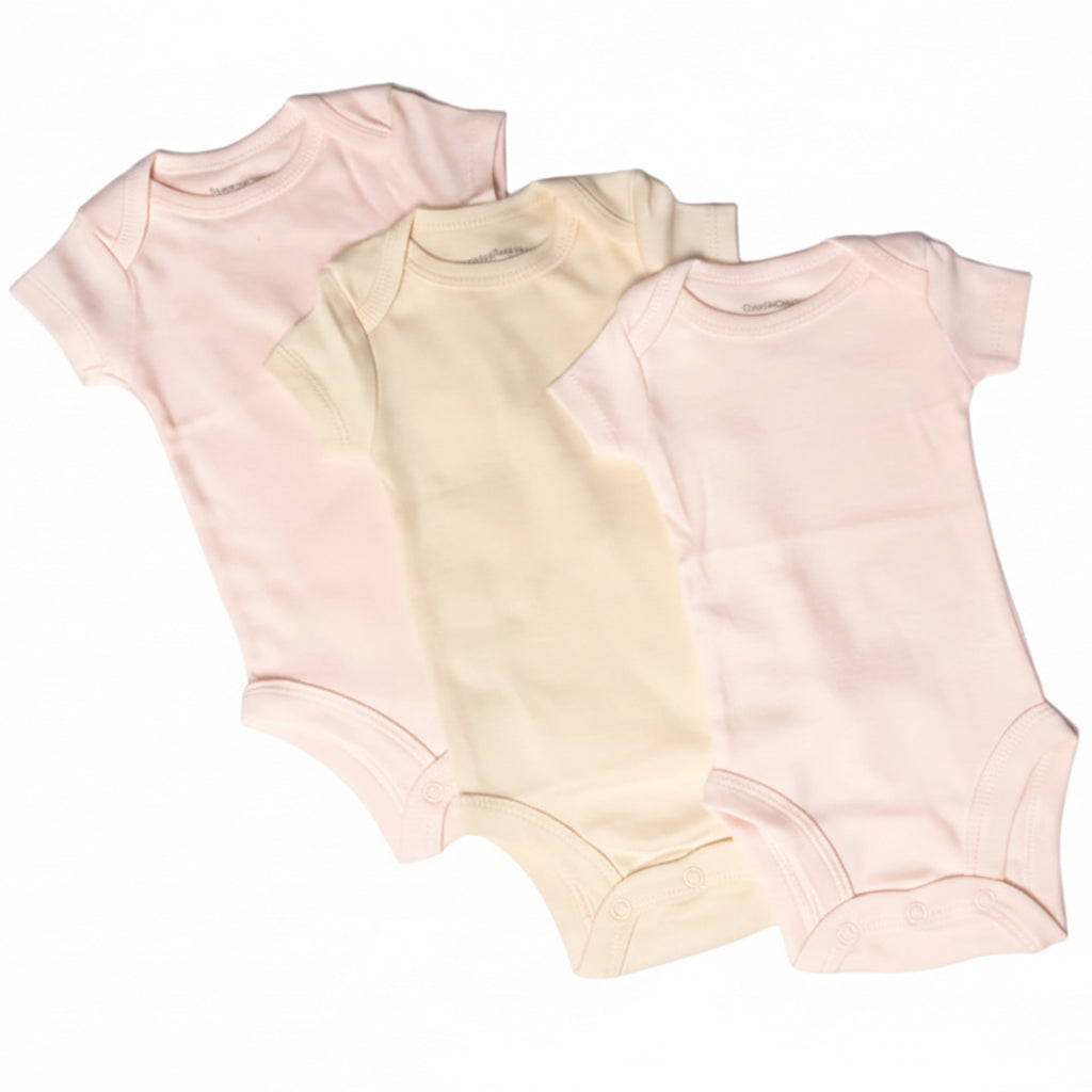 Three baby bodysuits in pink, beige, and light pink on a white background